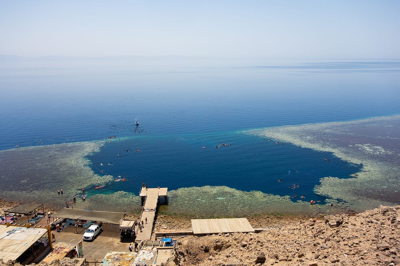 Snorkeler floating above the shallow coral reef edge of the Blue Hole near Dahab on the Sinai coast